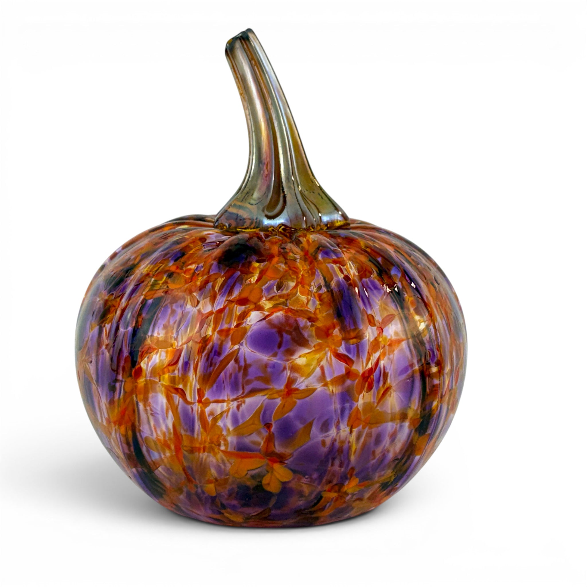 A decorative hand-blown glass pumpkin with a textured, marbled pattern of purple, orange, and amber tones, featuring a curved glass stem, set against a plain white background.