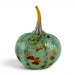 A hand-blown glass pumpkin with a ribbed body in iridescent mint green, speckled with orange, red, and brown, and topped with a curved amber-yellow stem, shown on a white background.