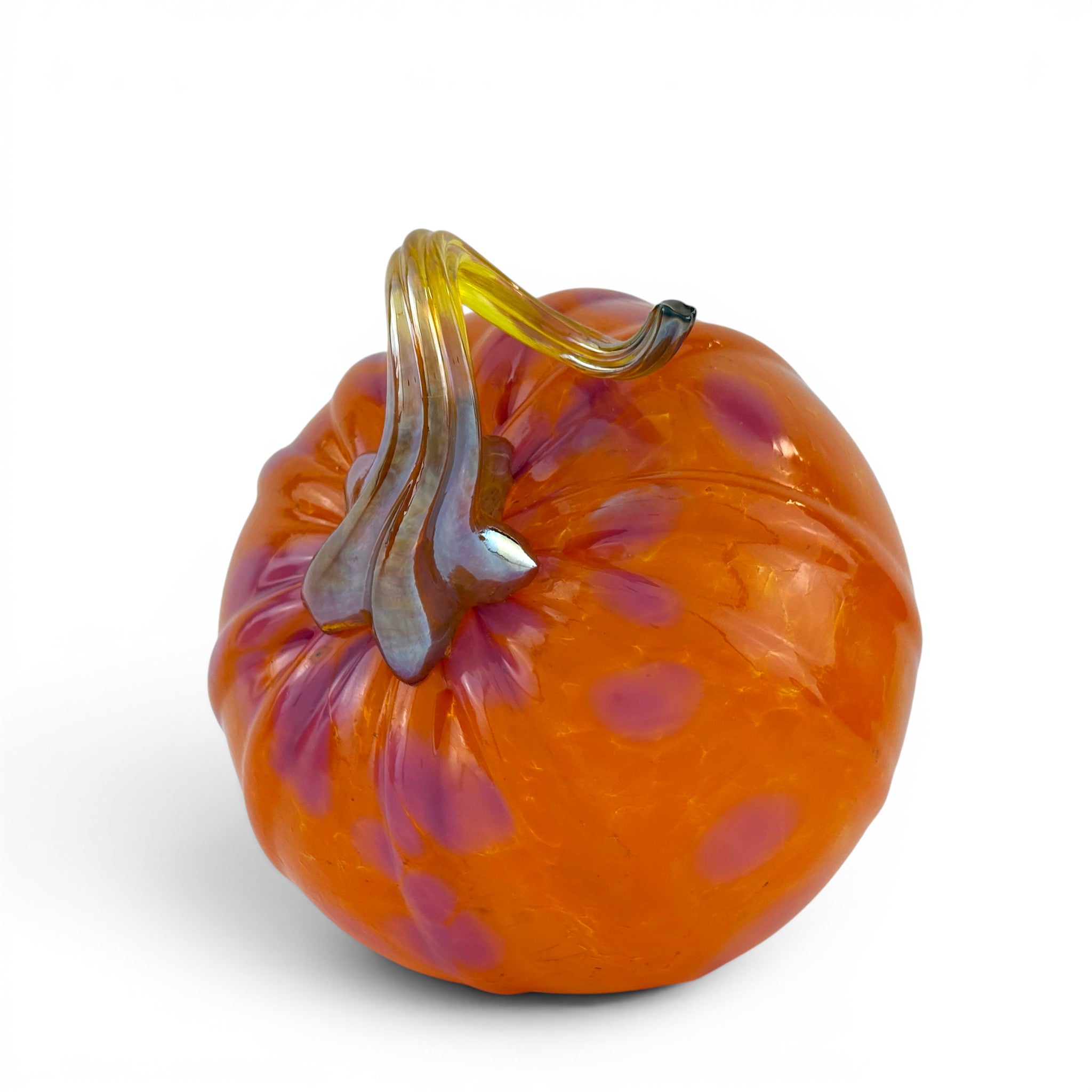 An orange glass pumpkin sculpture with purple speckles and a curved amber glass stem, shown on a white background.