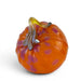 An orange glass pumpkin sculpture with purple speckles and a curved amber glass stem, shown on a white background.