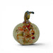 A hand-blown glass pumpkin figurine with a pale yellow-green base, decorated with orange, red, and brown marbled patterns, and featuring a dark brown stem, shown on a white background.