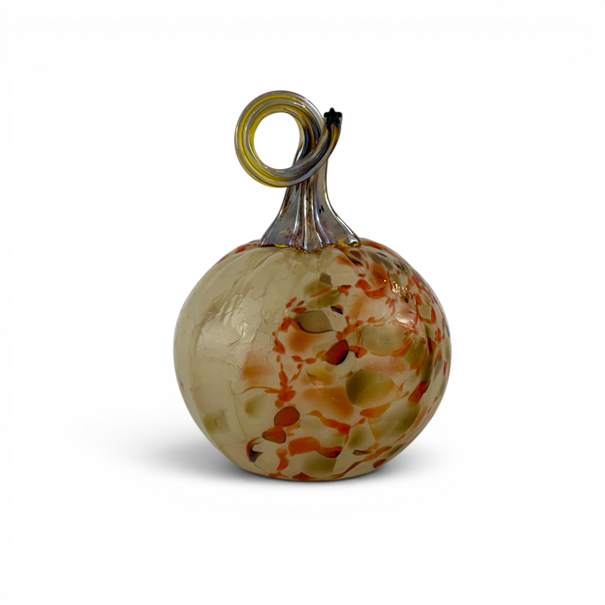 A decorative hand-blown glass pumpkin with a textured, marbled body in beige, orange, and green, featuring a twisted stem with a yellow-green loop at the top, set against a plain white background.