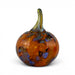 A hand-blown glass pumpkin with a rounded body in amber orange, featuring marbled swirls of blue, purple, and black, and a curved greenish-yellow stem, set against a plain white background.