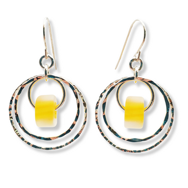 A pair of silver-colored double hoop earrings with blue glass beads attached to them.