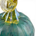 Close-up of a hand-blown glass decorative object with a rounded teal-green body and a twisted translucent yellow-green neck on a white background.