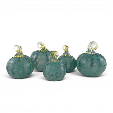 Five decorative glass pumpkins in a mottled teal green color with clear glass stems, arranged on a white background.