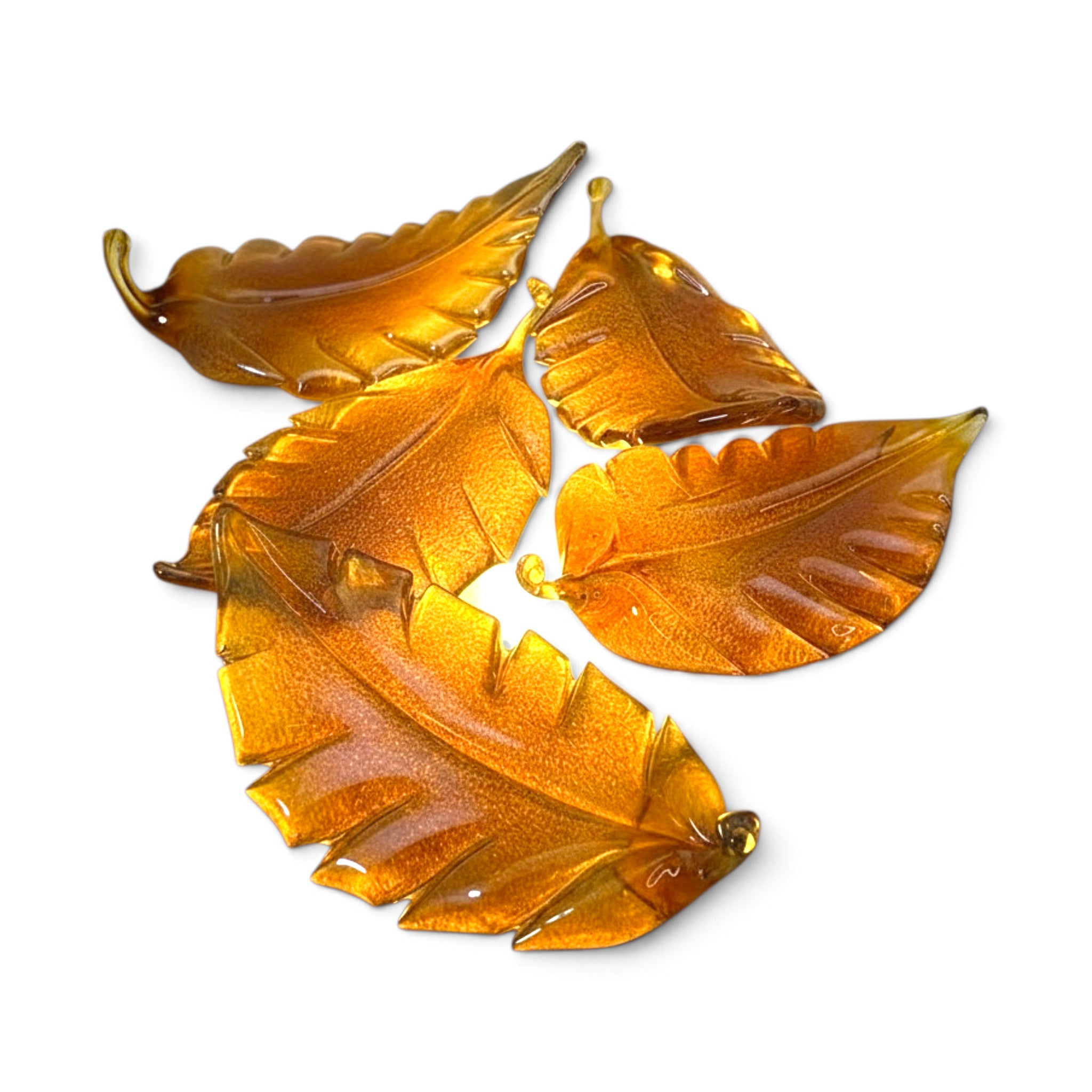 Five amber-colored translucent leaf-shaped glass beads arranged on a plain white background.