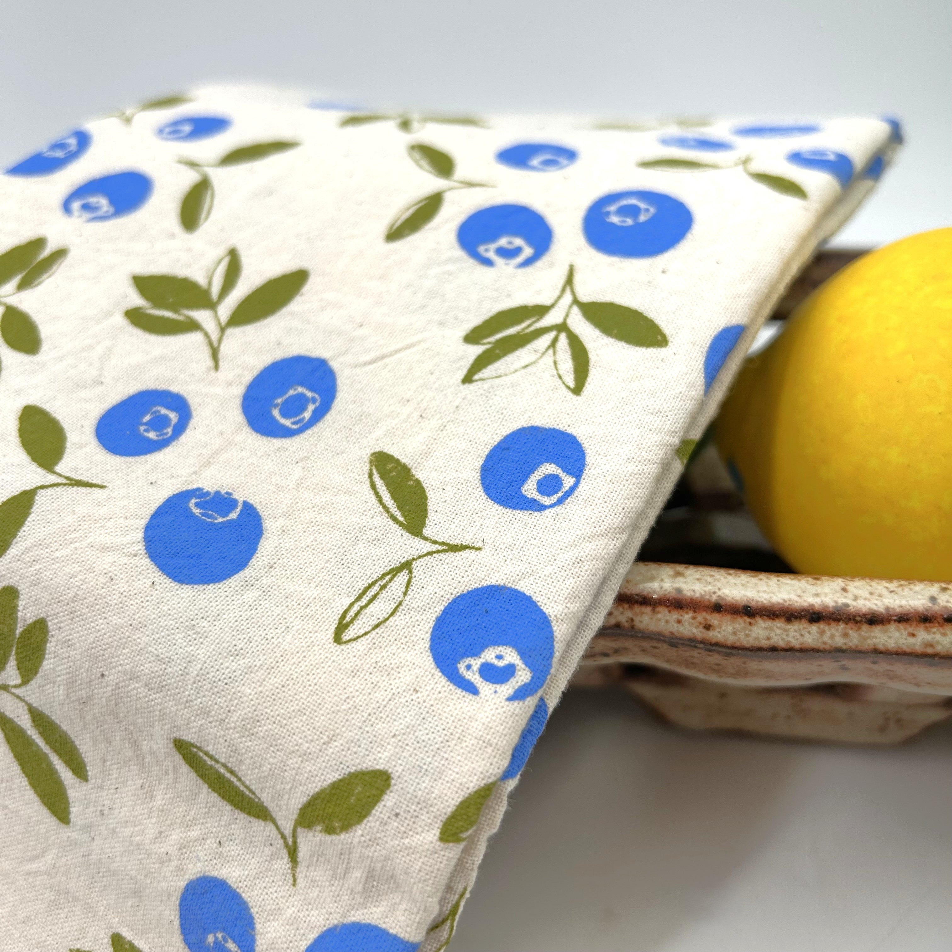 close view of hand-printed kitchen towel with an original blueberry design 