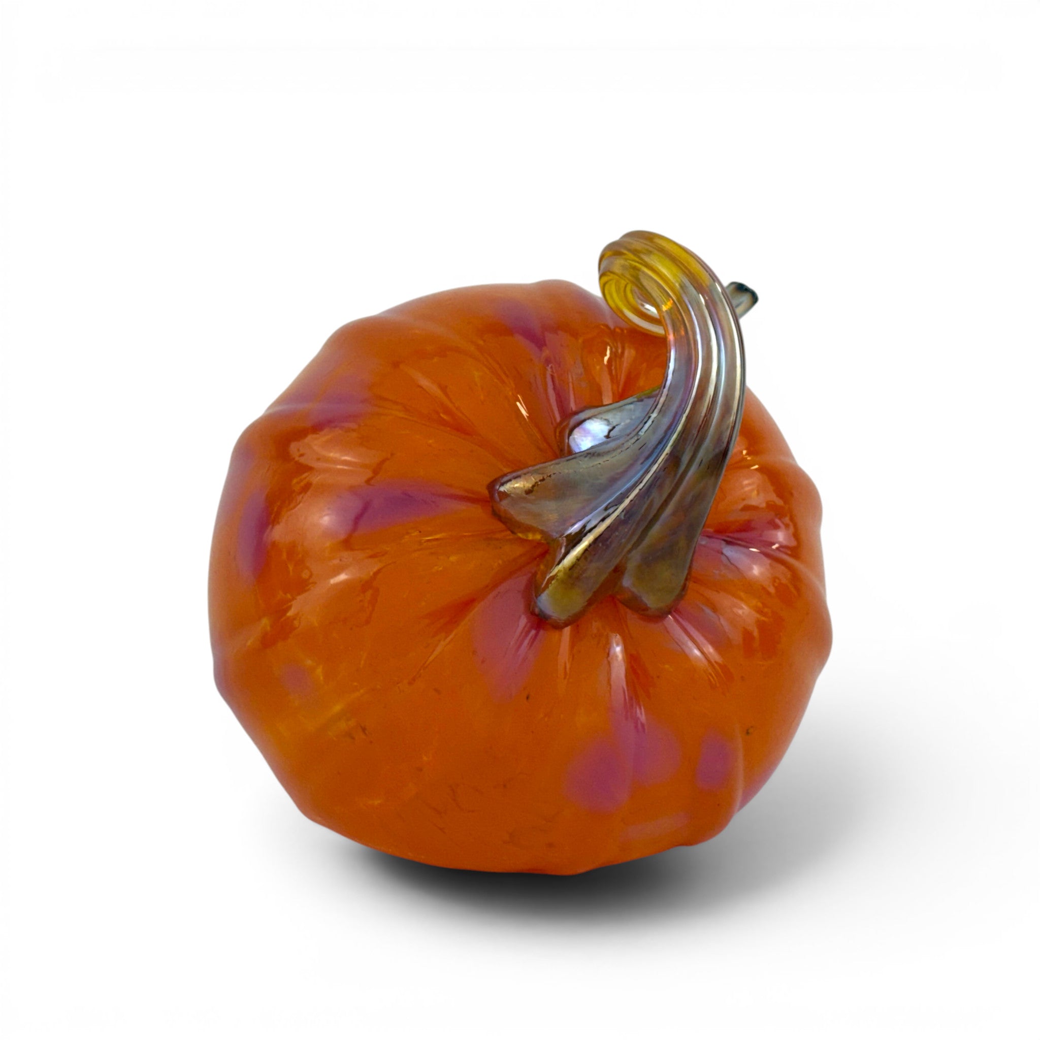 An orange glass pumpkin figurine with a curved amber and smoky brown stem, photographed on a clean white background.