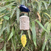Decorative ceramic bird bell hanging among green leaves