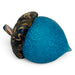 A hand-blown glass acorn with a textured cerulean body and a marbled dark brown, black, and gold cap.  