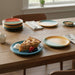 Dining table with colorful plates and dessert create a warm, inviting atmosphere