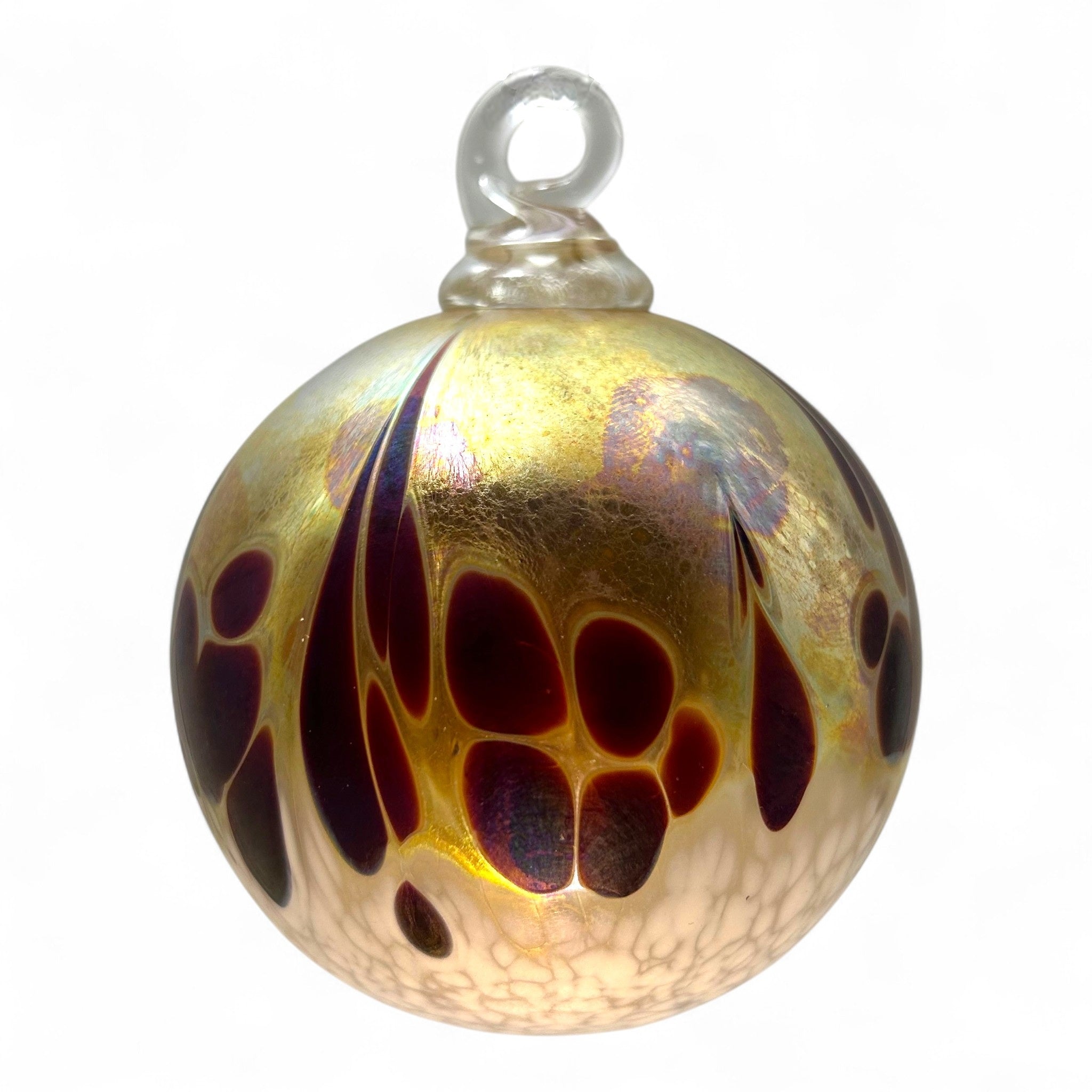 Decorative glass ornament with gold and brown patterns on a white background