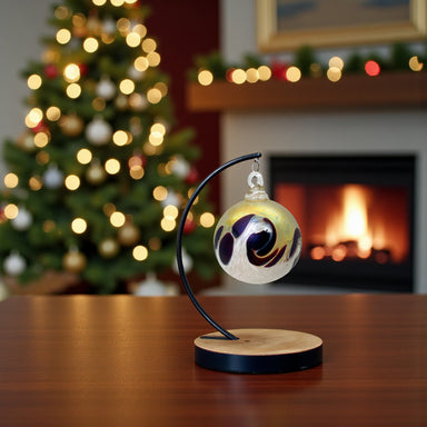 cranberry-gold handcrafted holiday ornament hanging in front of holiday decorations