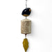 Decorative hanging stoneware bird bell with a coneflower cylindrical design and leaf-shaped finial 
