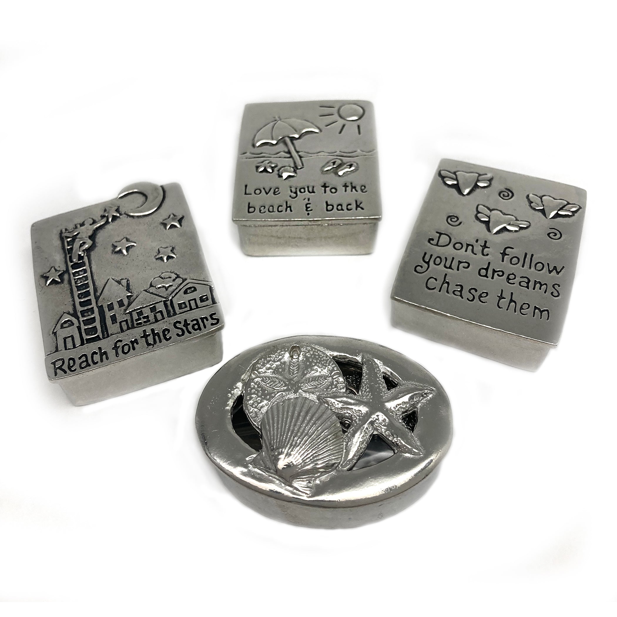 Four pewter wish boxes with different designs including seashells, stars, a lighthouse, and text phrases, each with a matching necklace on a chain.