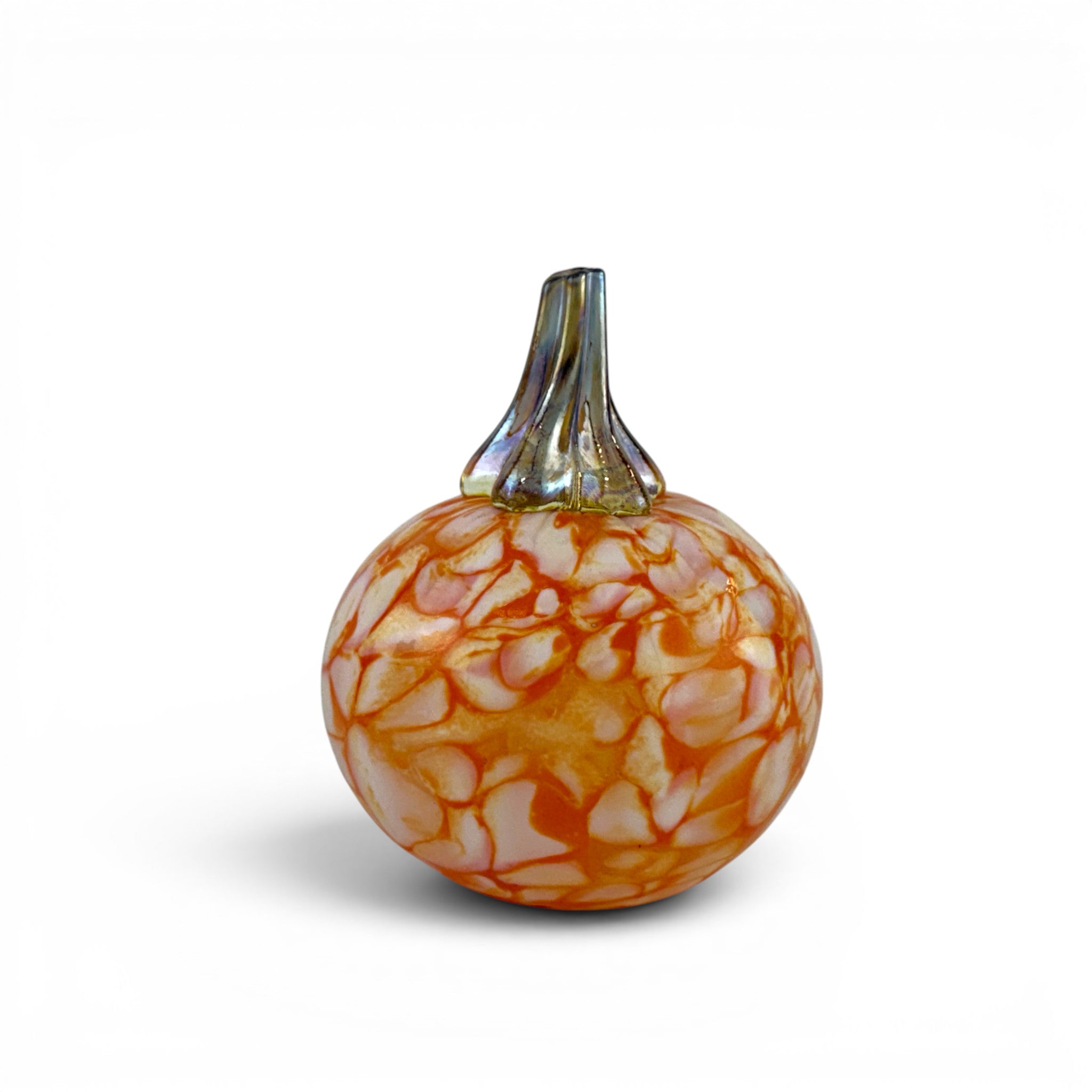 A decorative glass pumpkin with an orange and white marbled pattern and a textured green stem, shown on a clean white background.