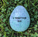 Blue textured egg on grass with text '1 Ticket for $10'