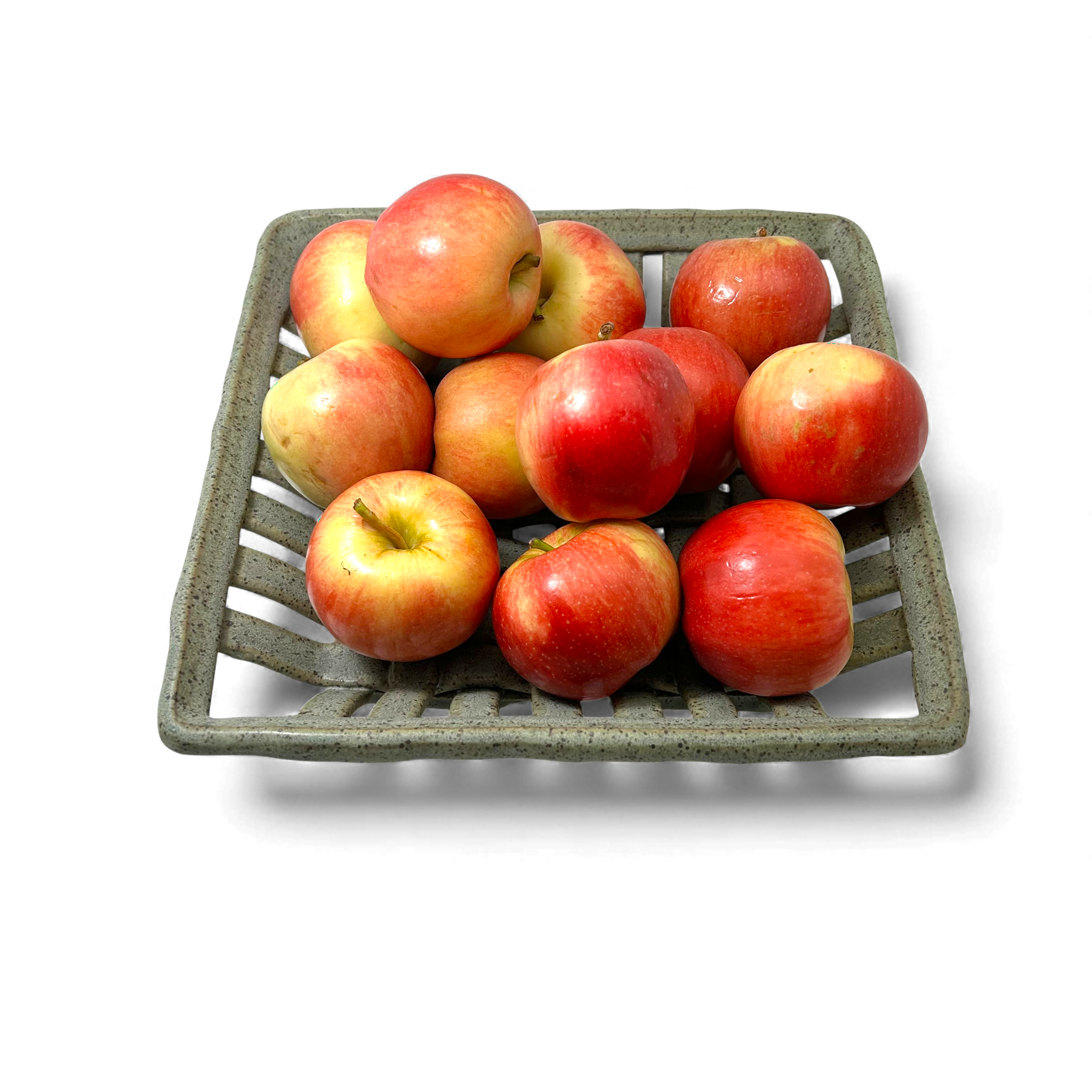 red apples in a handcrafted ceramic woven basket