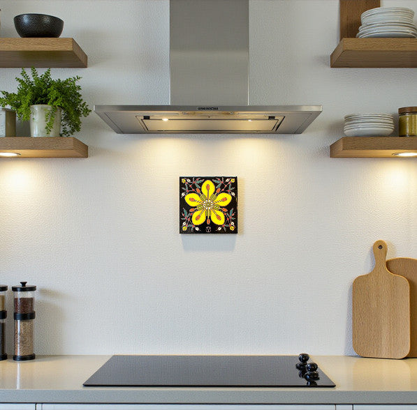 Modern kitchen with a decorative hand-glazed art tile hanging on the wall featuring a yellow flower design.
