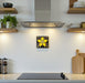 Modern kitchen with a decorative hand-glazed art tile hanging on the wall featuring a yellow flower design.
