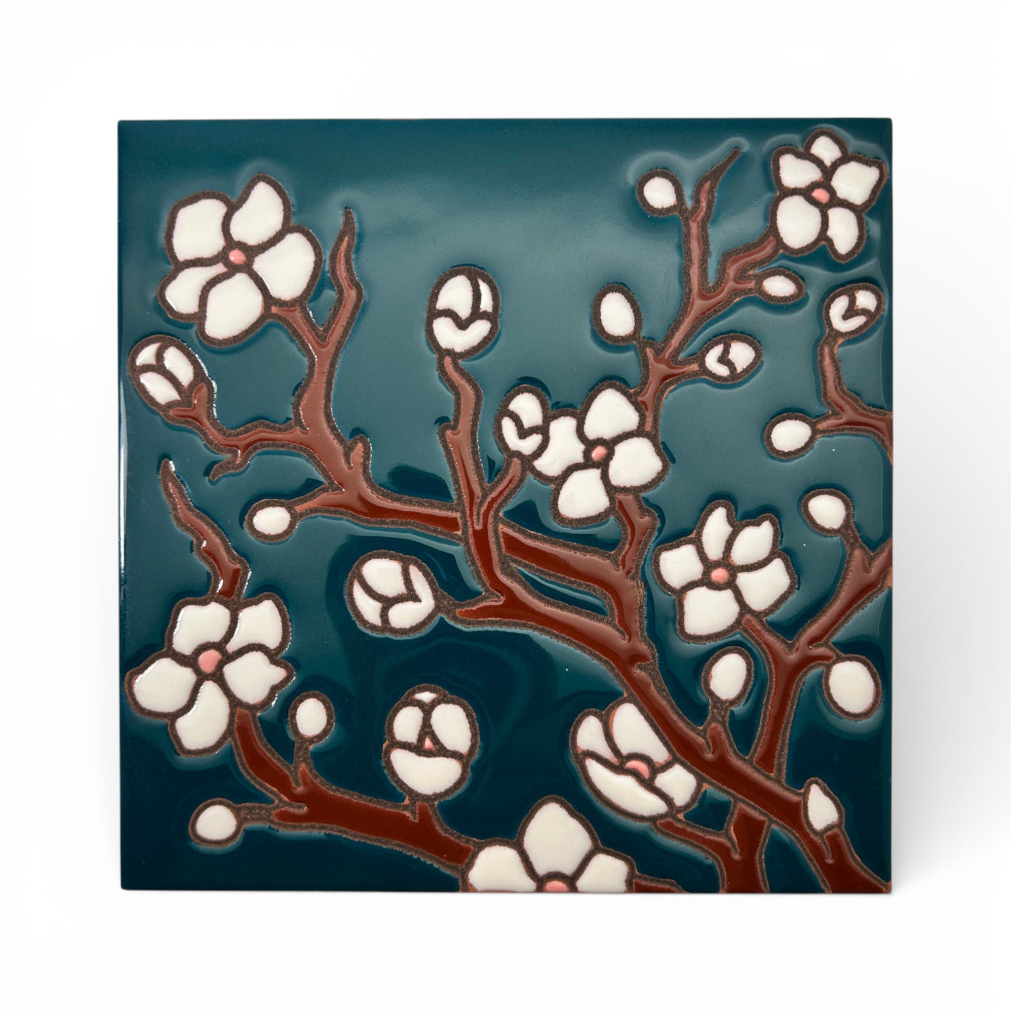 Decorative tile with floral design on a teal background