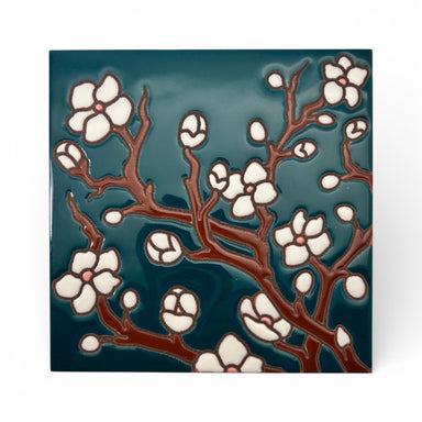 Decorative tile with floral design on a teal background