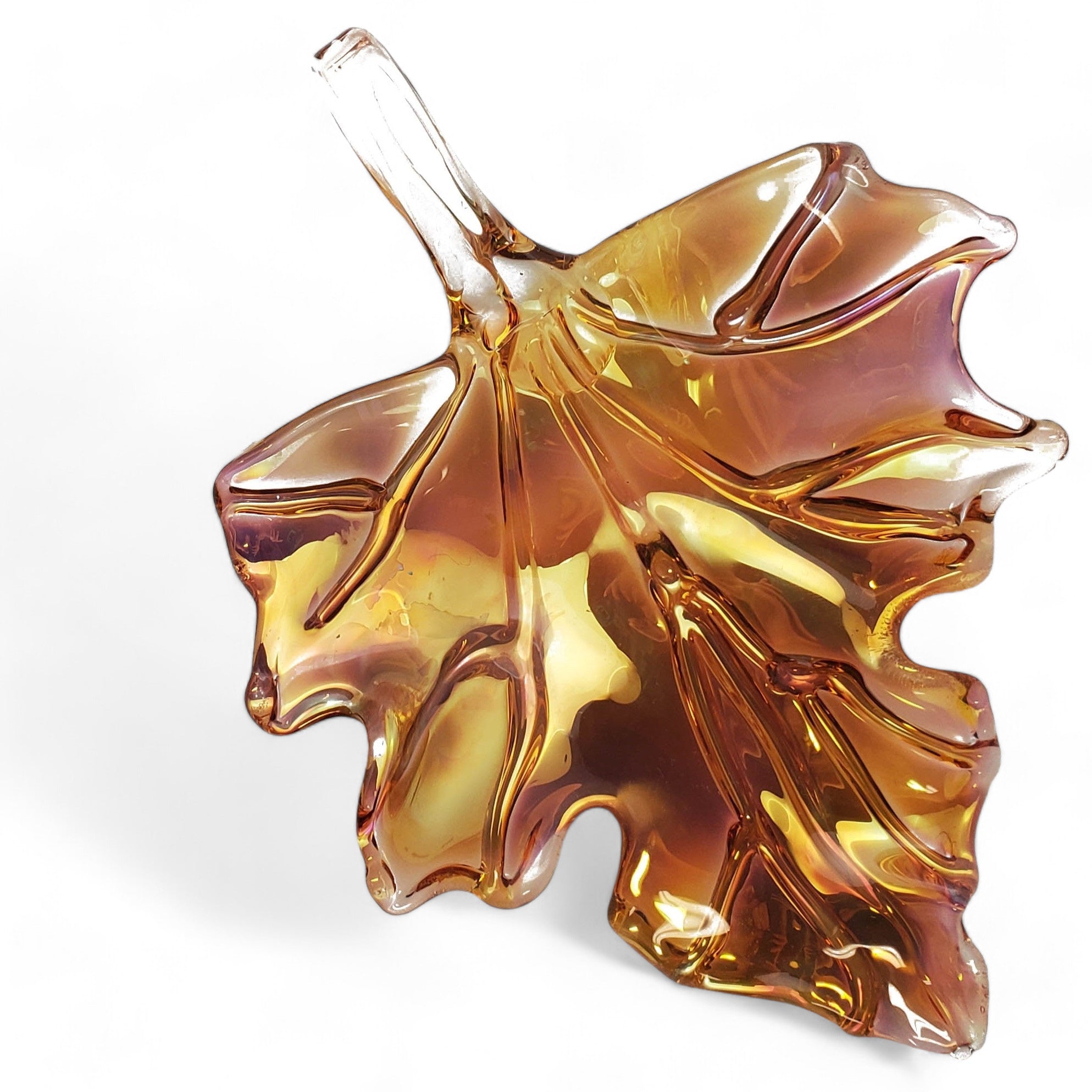 A glass sculpture of an amber leaf with a metallic sheen, designed for hanging or flat display.