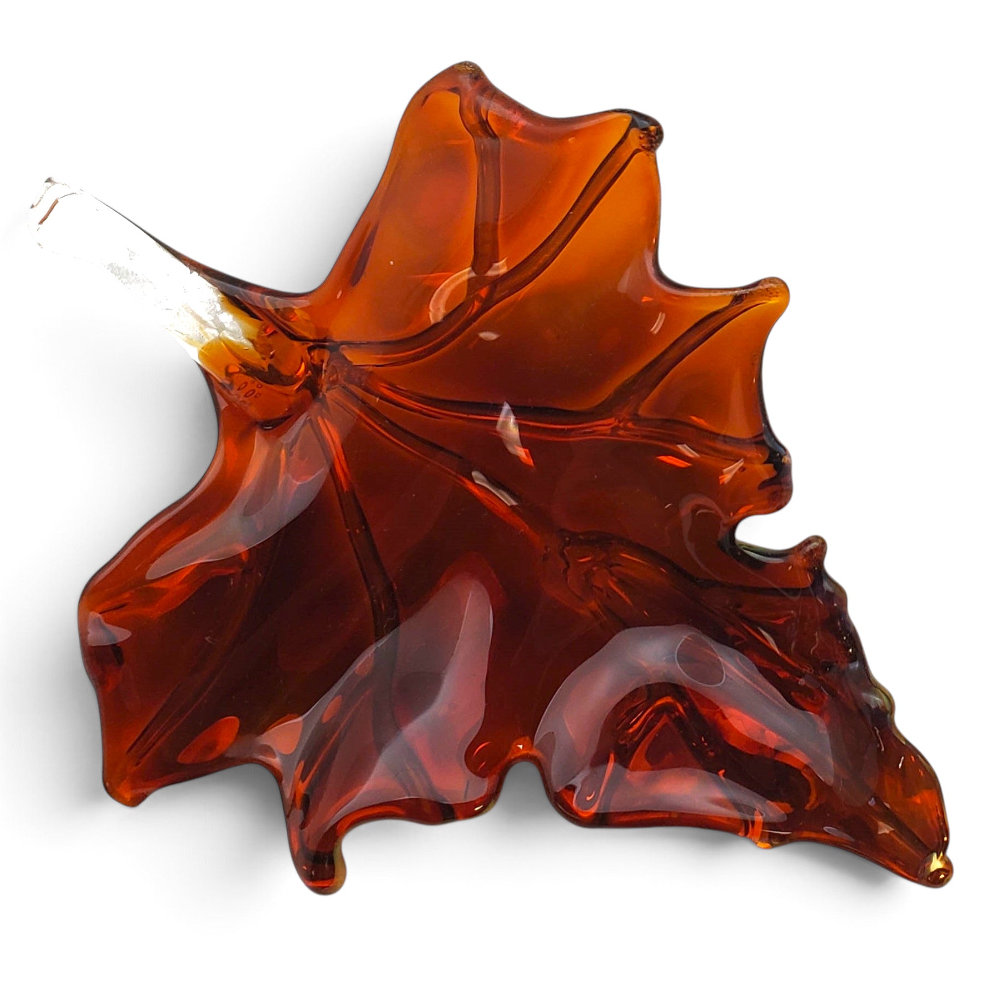 A translucent amber-brown glass ornament shaped like a maple leaf with a stem. 