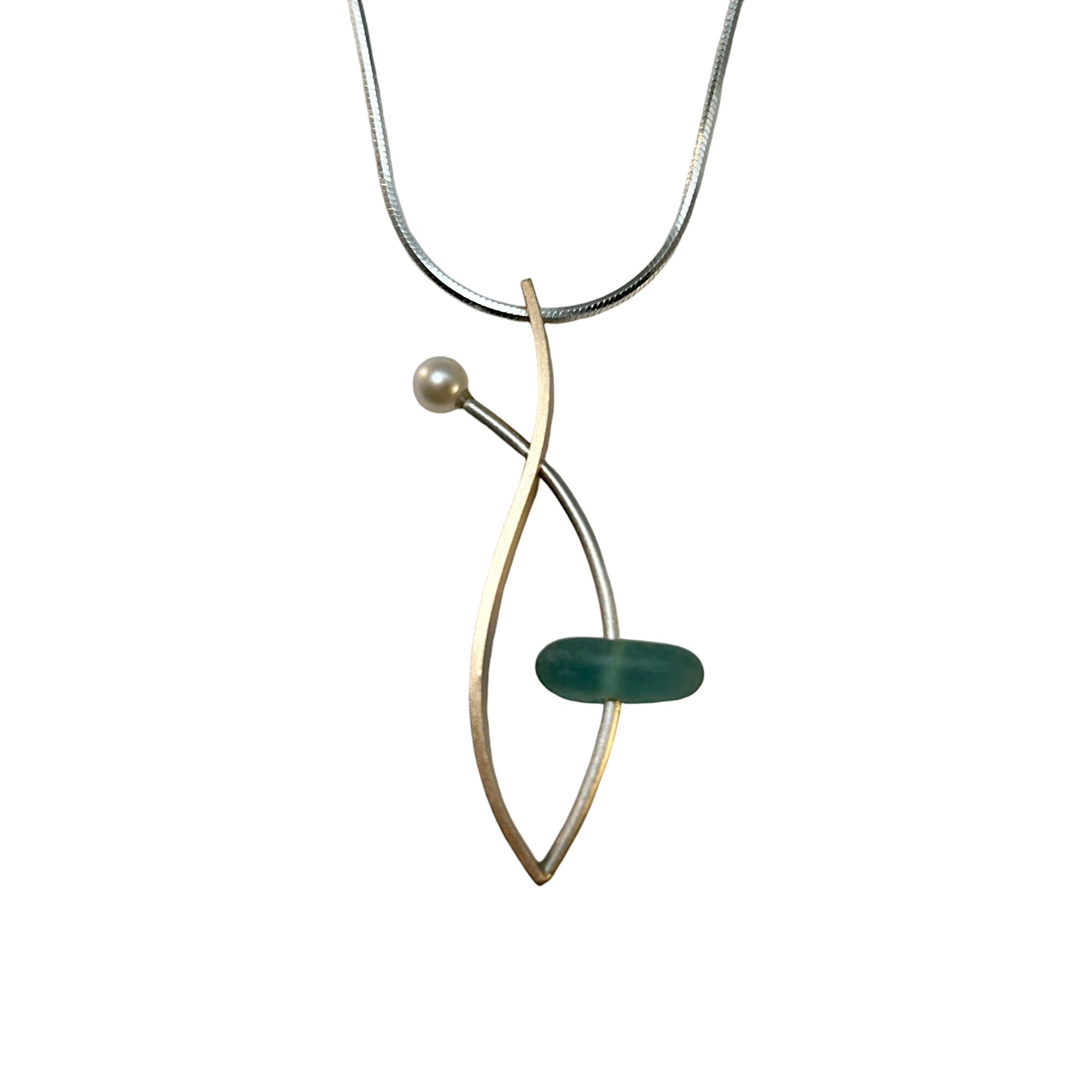A sea glass necklace with a contemporary design, featuring a brushed sterling silver chain, a gold fill pendant, and a pearl accent.