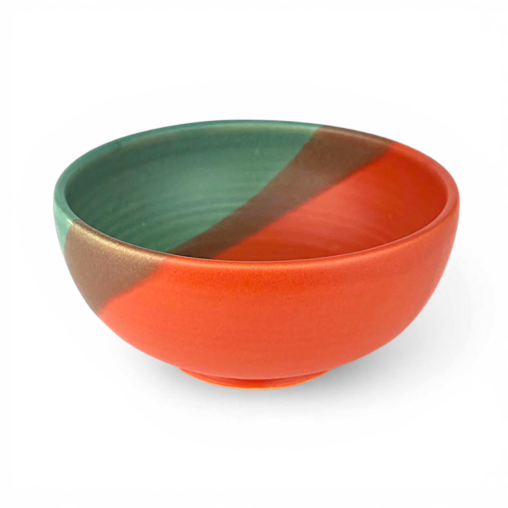 Color-blocked ceramic bowl with green, brown, and orange sections on a white background