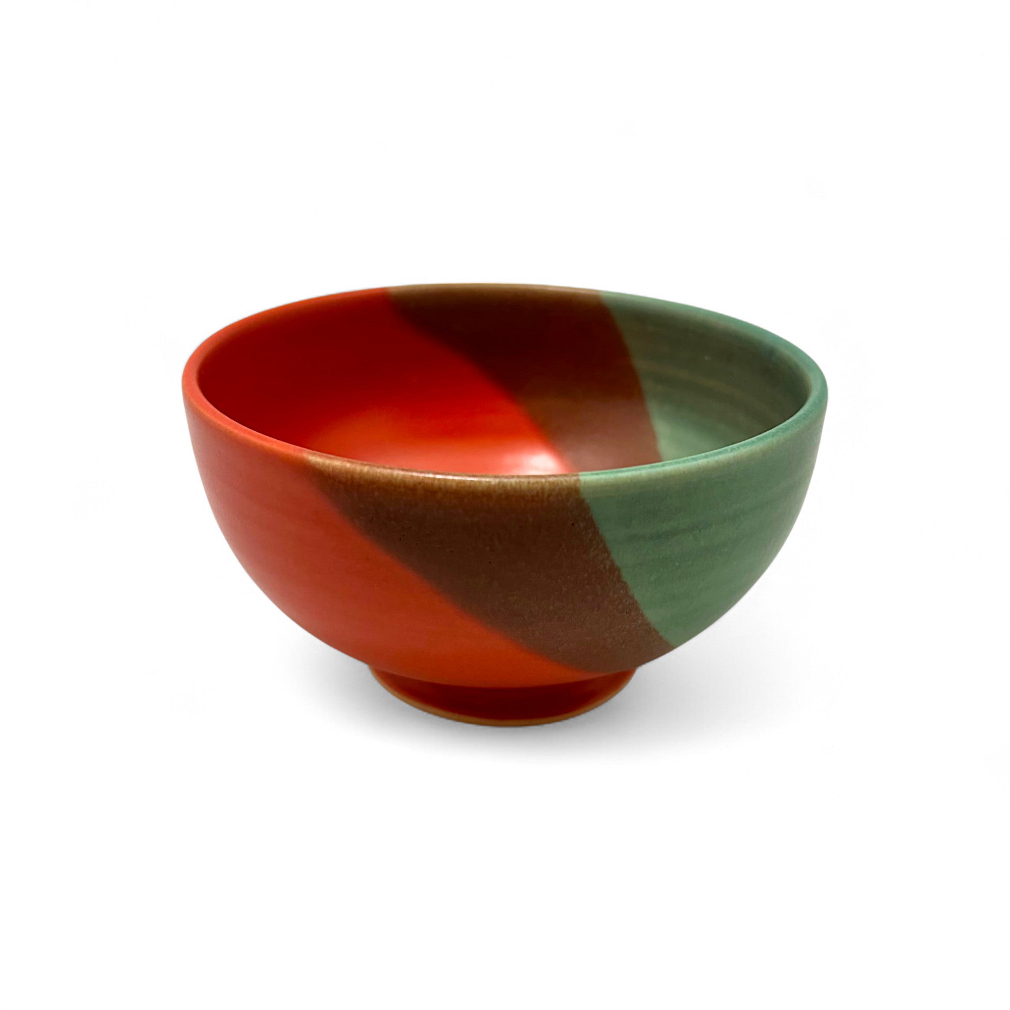 Color-blocked ceramic bowl with red, brown, and green sections on a white background