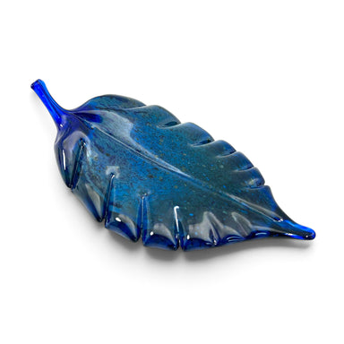 A hand-blown glass leaf sculpture in a deep cobalt blue color with subtle darker blue speckles.  