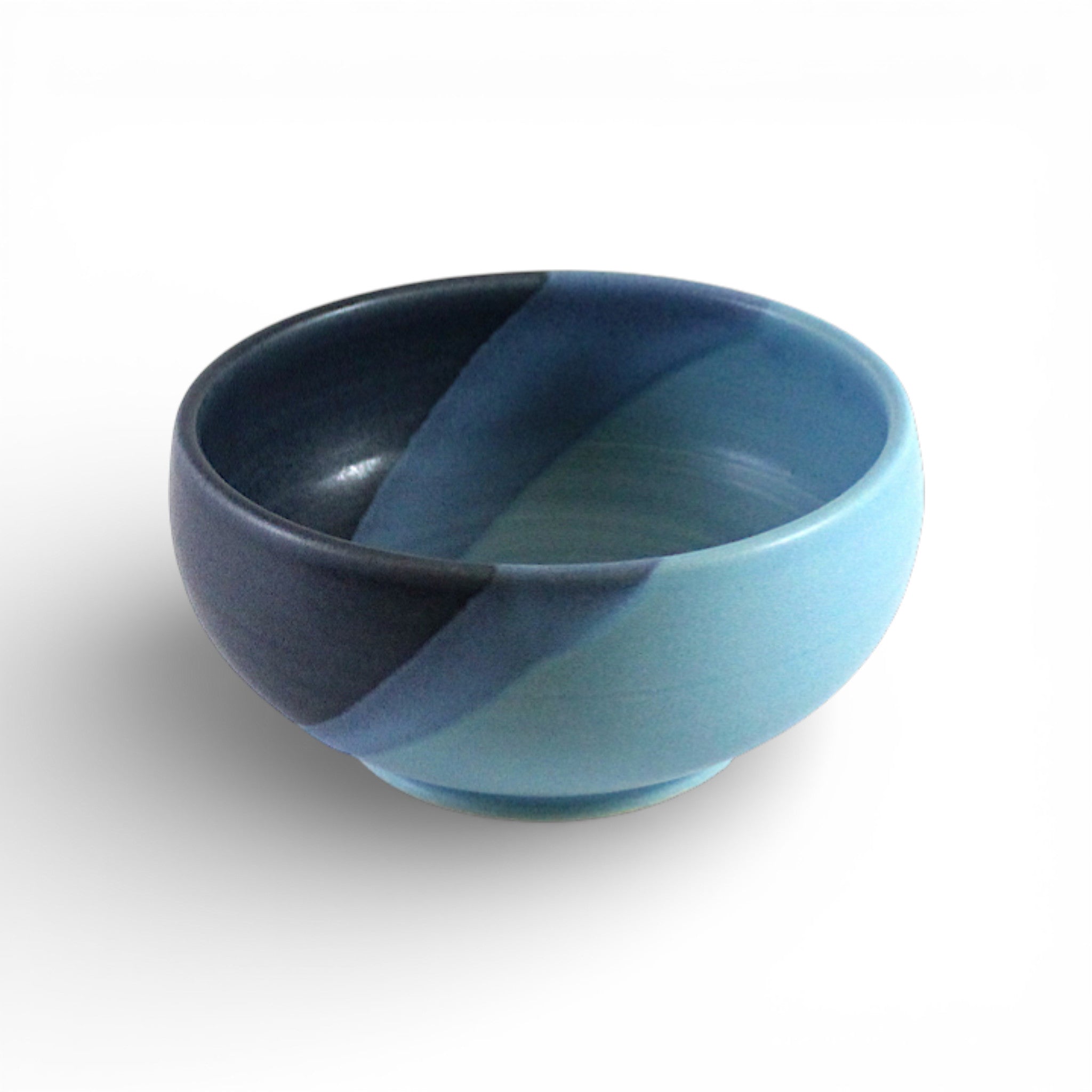 Ceramic bowl with blue and dark blue glaze on a white background