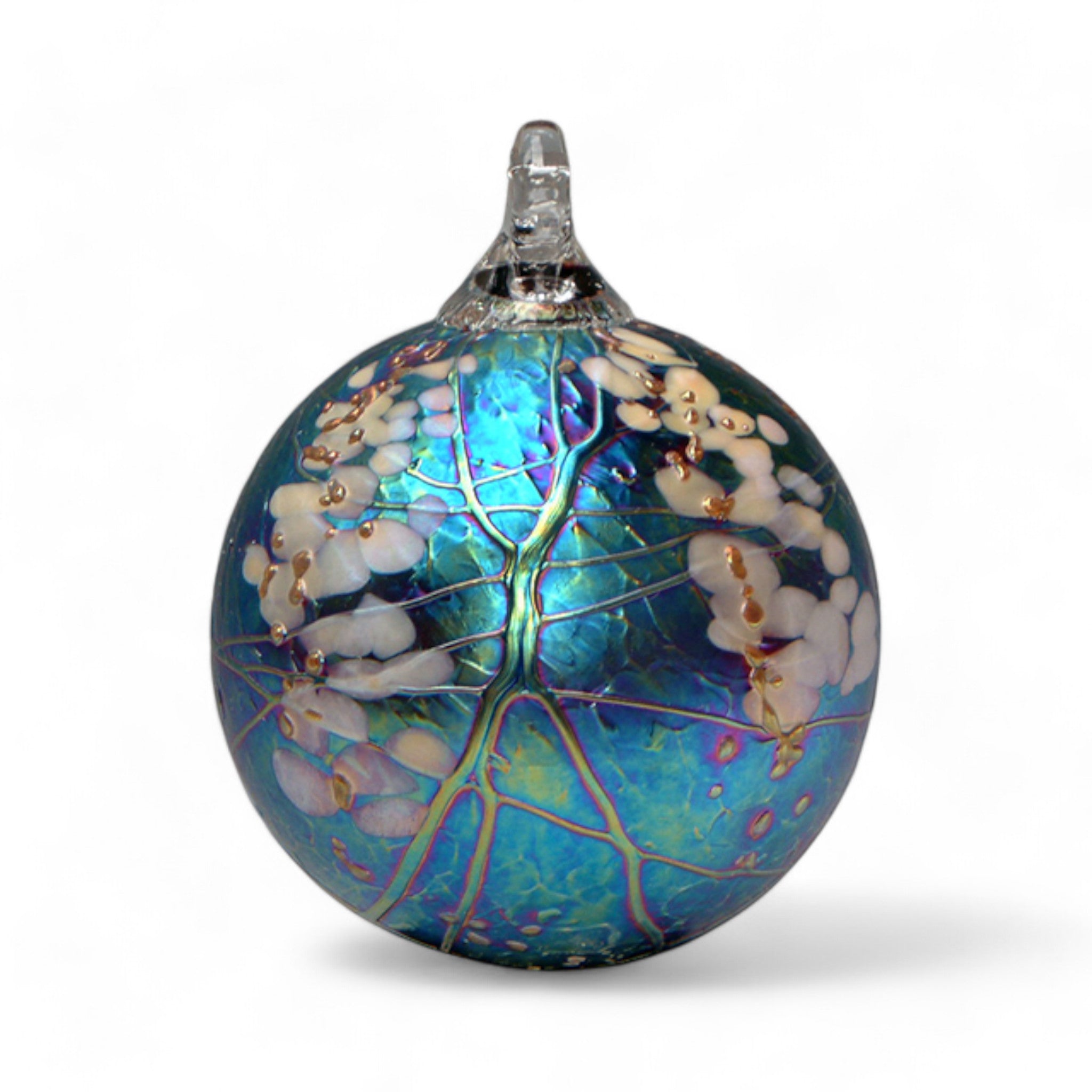 A handcrafted glass ornament with a round shape, featuring a geometric pattern created by colored glass chips that resembles blossoms and vines. The ornament has a loop on top for hanging.