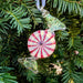 peppermint candy handmade glass ornament hanging on a holiday tree