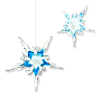 Two handcrafted snowflake ornaments in ice blue and white colors, with a 7”-8" diameter, suspended by strings.