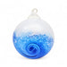 A hand blown glass ornament with a wave design, predominantly blue, with a white top presumably for hanging.