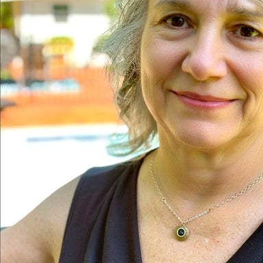Woman with a necklace smiling outdoors