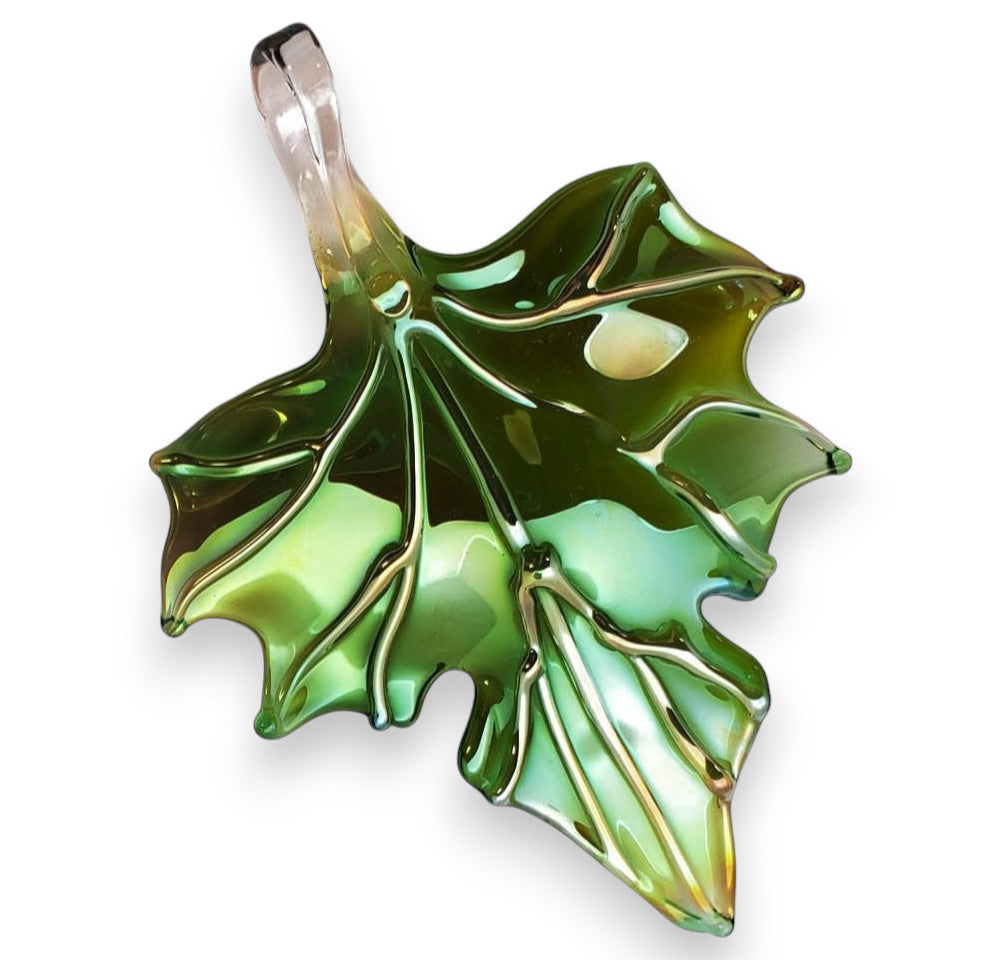 A green glass sculpture of an autumn leaf with a metallic sheen.
