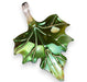 A green glass sculpture of an autumn leaf with a metallic sheen.