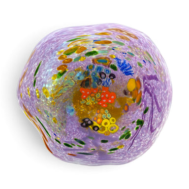 A reef bowl hand-blown glass art piece with a lavender-purple base and multicolored glass inclusions, including orange, yellow, green, blue, and black details.