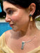 Close-up of a woman wearing earrings and a necklace with a blurred background
