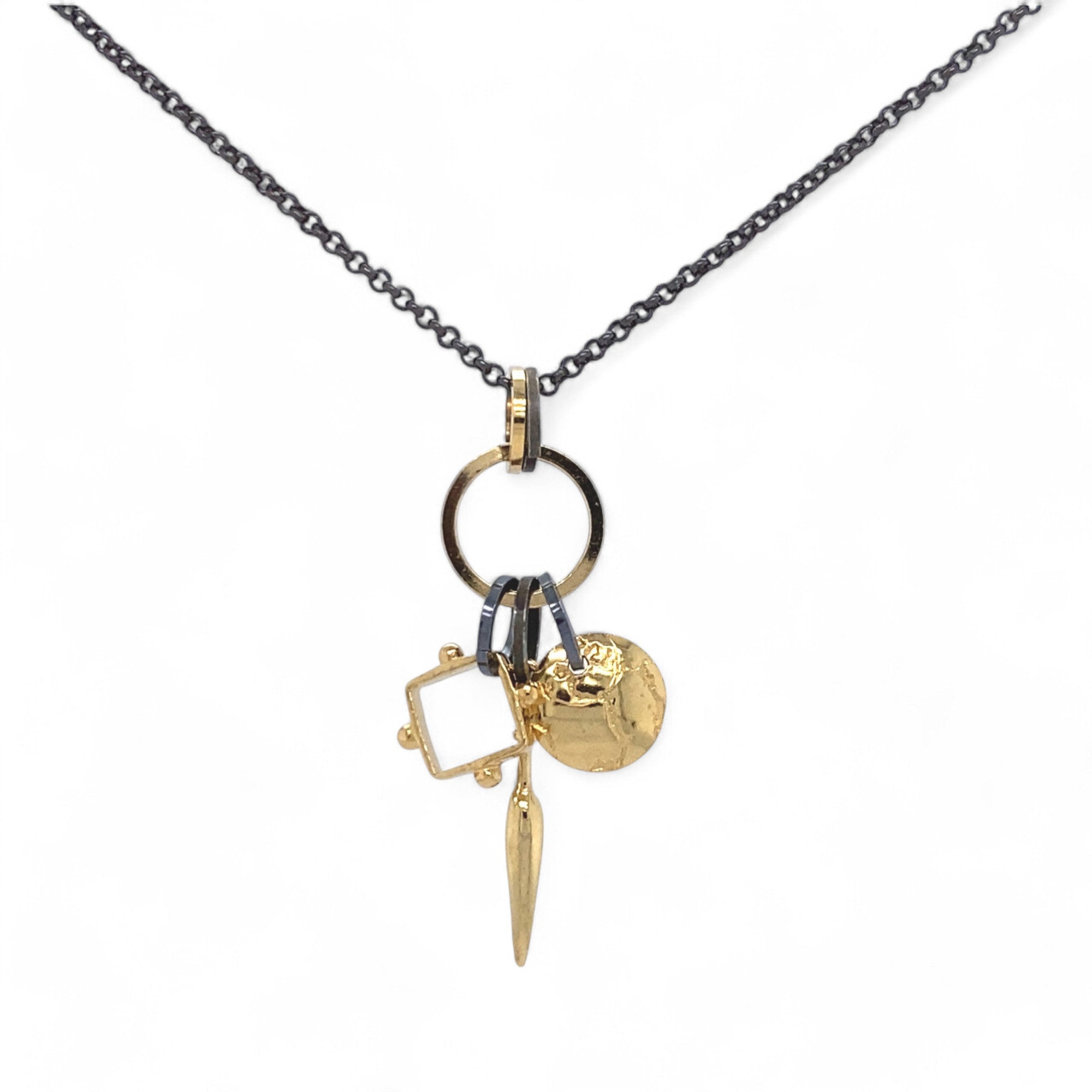 A trio of handcrafted charms complete this handcrafted necklace