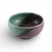 Two-toned ceramic bowl with green and purple colors on a white background