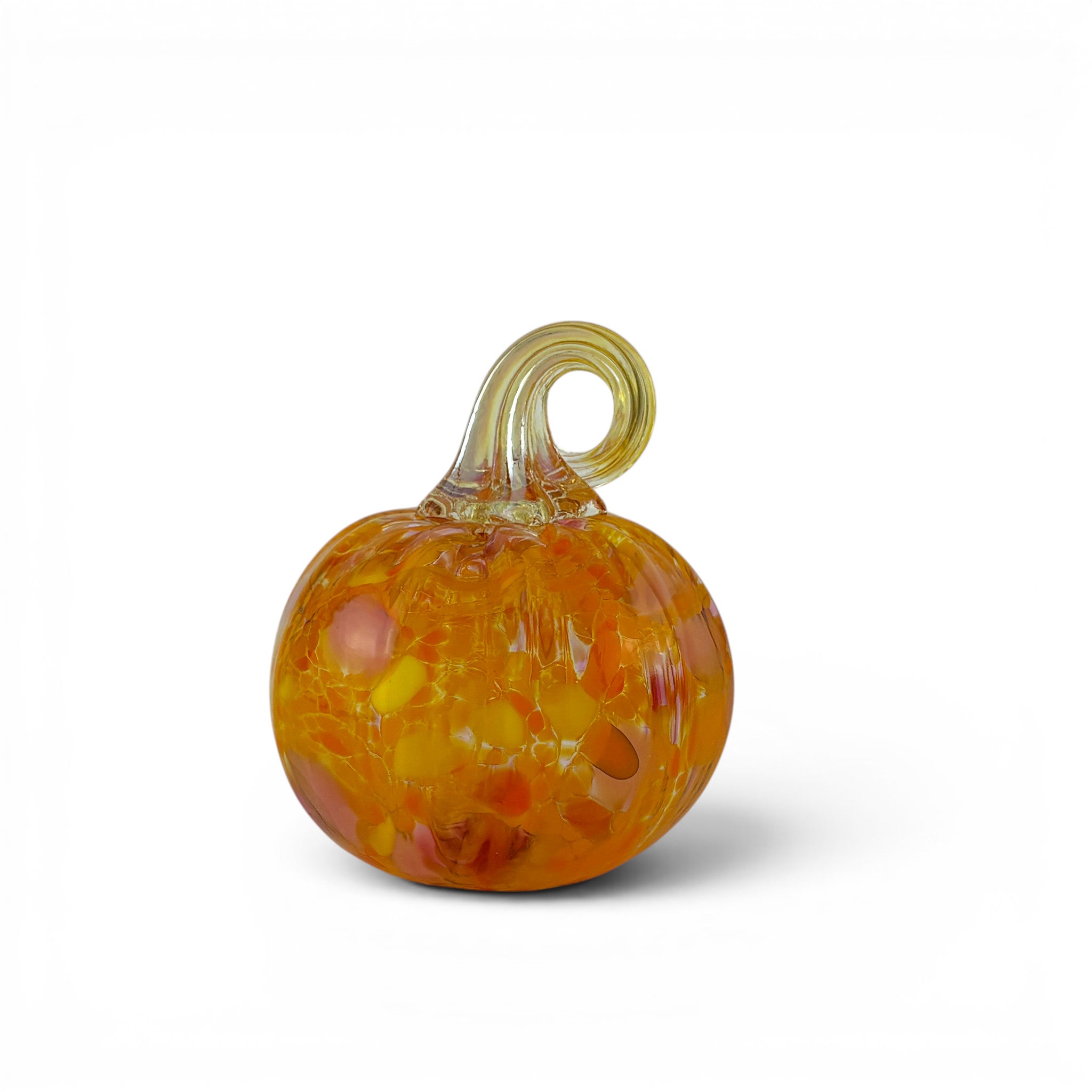 An orange glass pumpkin figurine with a twisted stem, featuring internal swirls of yellow, red, and orange, set against a plain white background.