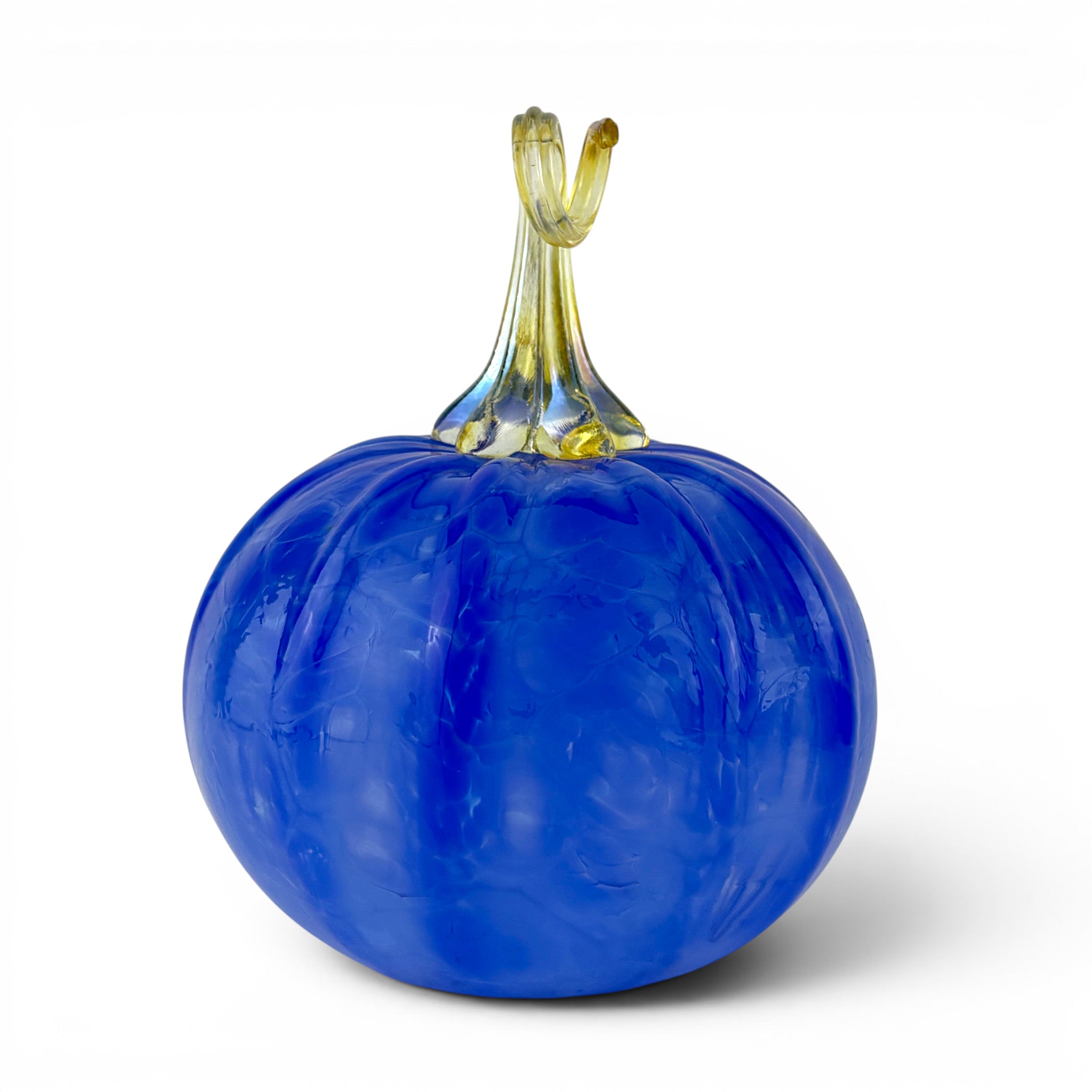 A decorative glass pumpkin sculpture with a vibrant cobalt blue bulbous body and a translucent yellow-green stem, shown on a clean white background.