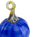 A close-up of a decorative glass pumpkin sculpture with a vibrant cobalt blue body and a twisted amber-yellow stem on a white background.