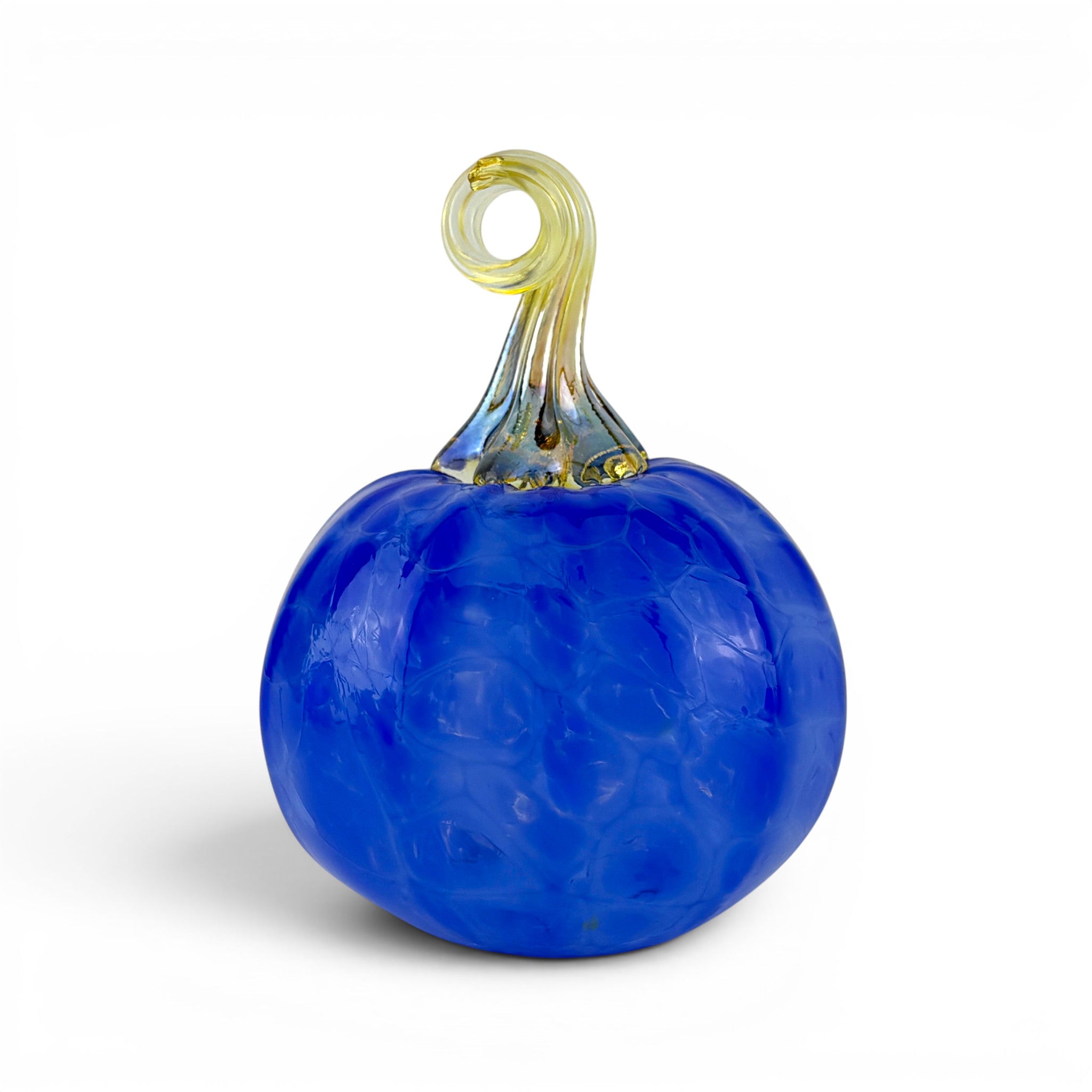 A decorative glass pumpkin sculpture with a textured cobalt blue body and a twisted stem in pale yellow and blue, shown on a white background.