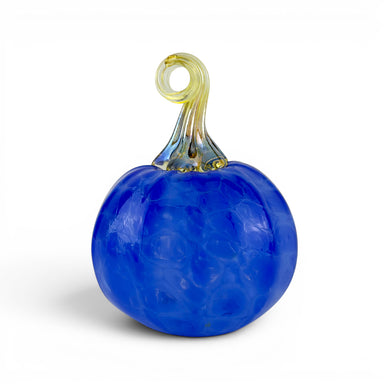 A decorative glass pumpkin sculpture with a textured cobalt blue body and a twisted stem in pale yellow and blue, shown on a white background.